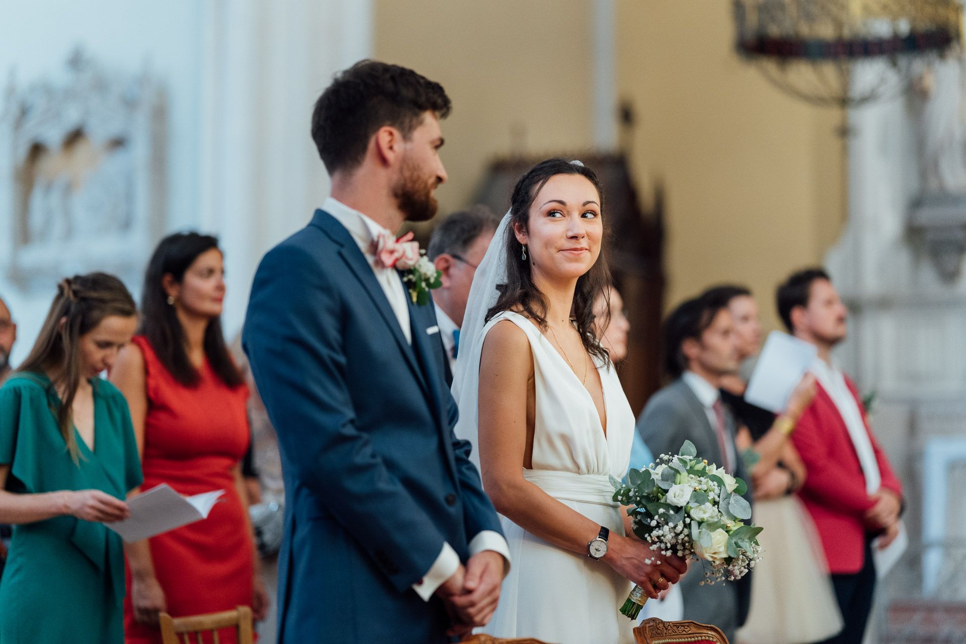 Photo d'une cérémonie de mariage à l'église. La mariée regarde son mari amoureusement.