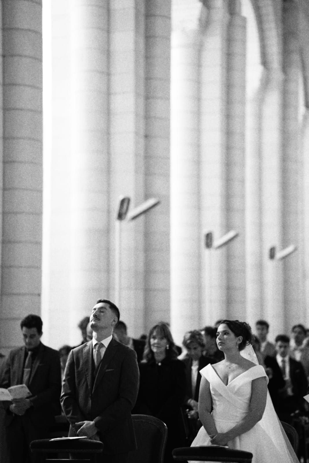 Photo d'une cérémonie de mariage à l'église. La mariée regarde son mari amoureusement.